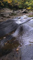 Ruisseau d'eau d'automne courant sur les rochers